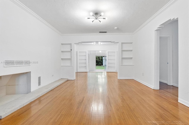 unfurnished living room featuring built in features, visible vents, light wood-style flooring, ornamental molding, and baseboards