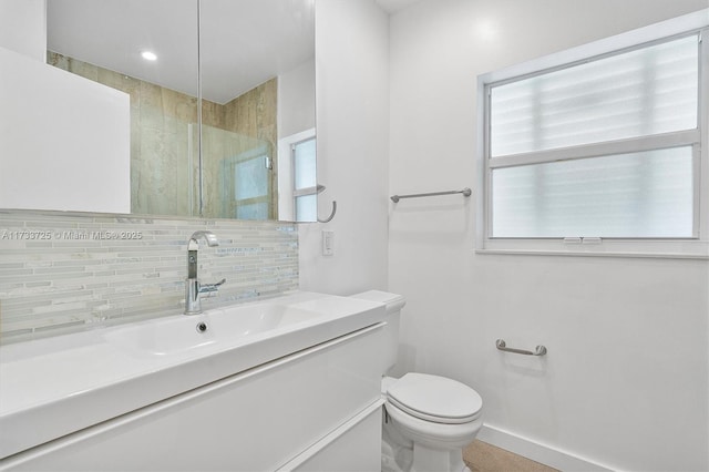 bathroom with tasteful backsplash, toilet, a shower stall, vanity, and baseboards