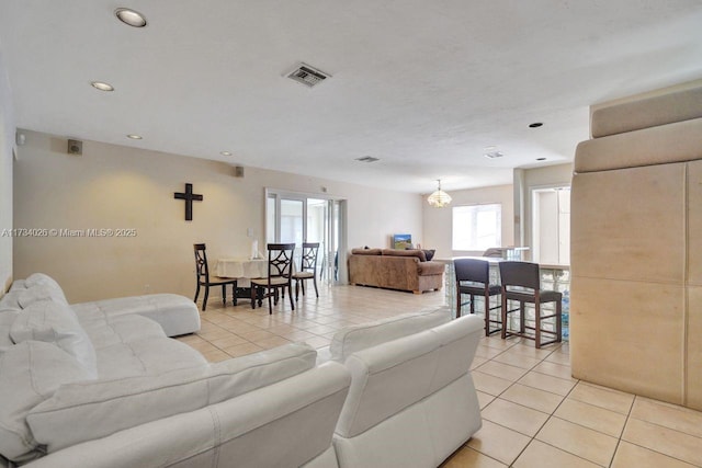 living area with light tile patterned floors, visible vents, and recessed lighting