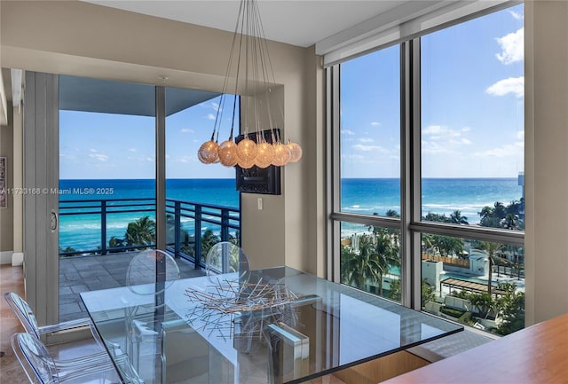 dining area with a water view and a wall of windows