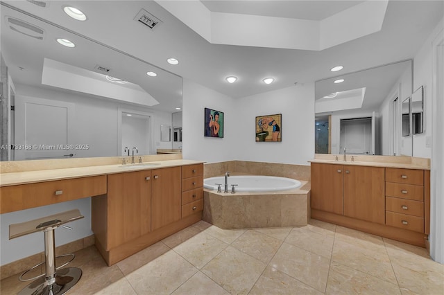 bathroom with vanity, tiled bath, a raised ceiling, and tile patterned flooring