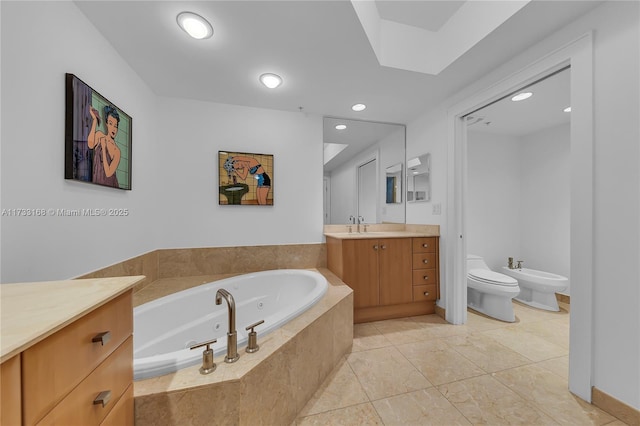 bathroom featuring tile patterned flooring, vanity, a relaxing tiled tub, toilet, and a bidet