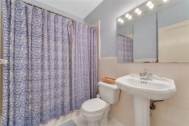 bathroom featuring tile walls, tile patterned floors, a shower with shower curtain, and toilet