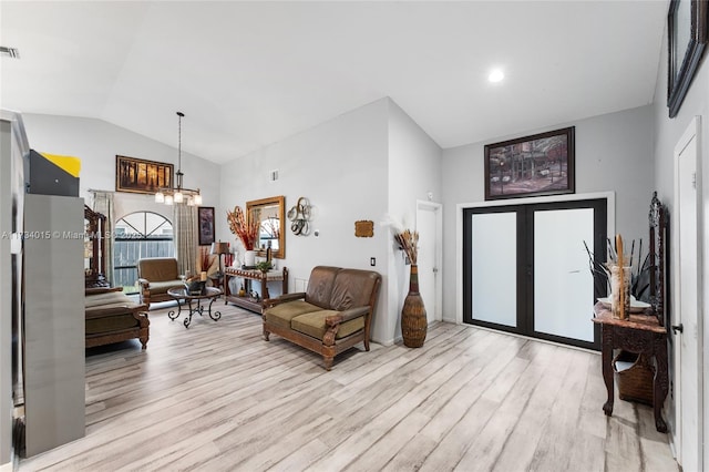 living room with french doors, lofted ceiling, light hardwood / wood-style flooring, and a notable chandelier