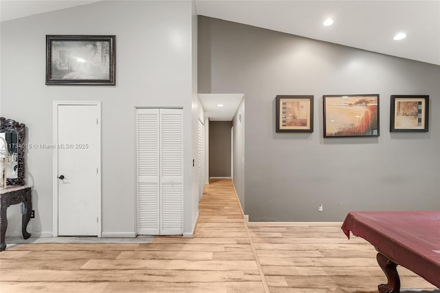 corridor featuring vaulted ceiling and light wood-type flooring