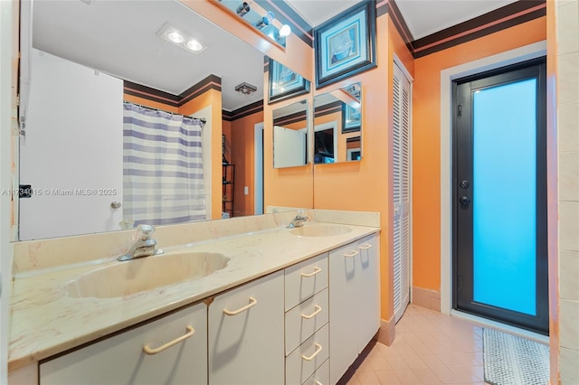 bathroom featuring crown molding, tile patterned floors, and vanity