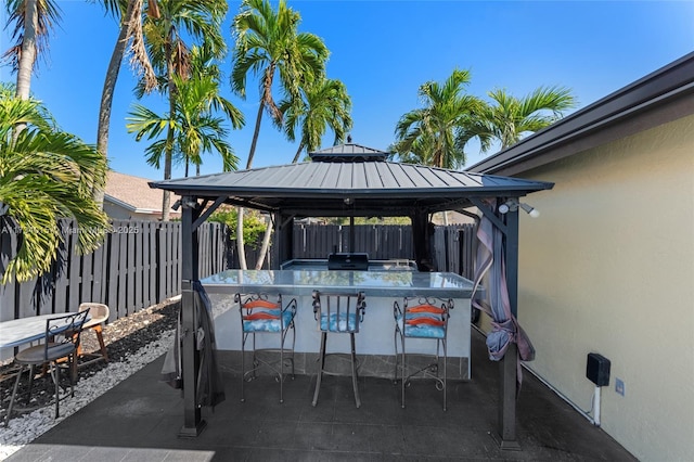 view of patio / terrace featuring a gazebo, exterior bar, and a grill