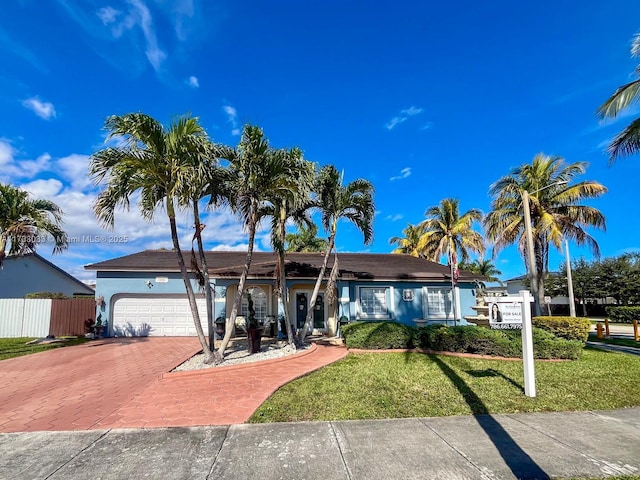 ranch-style home with a garage and a front yard