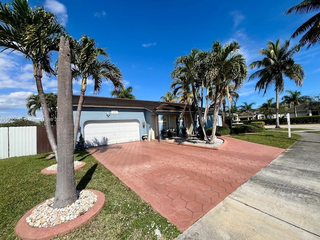 ranch-style home with a garage and a front lawn