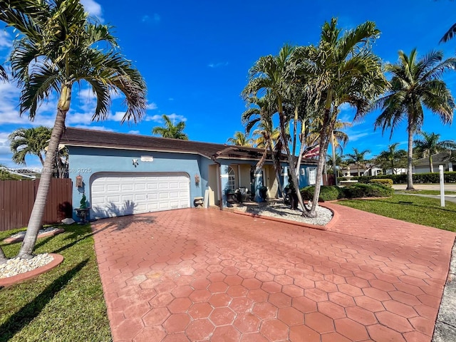 single story home featuring a garage and a front yard