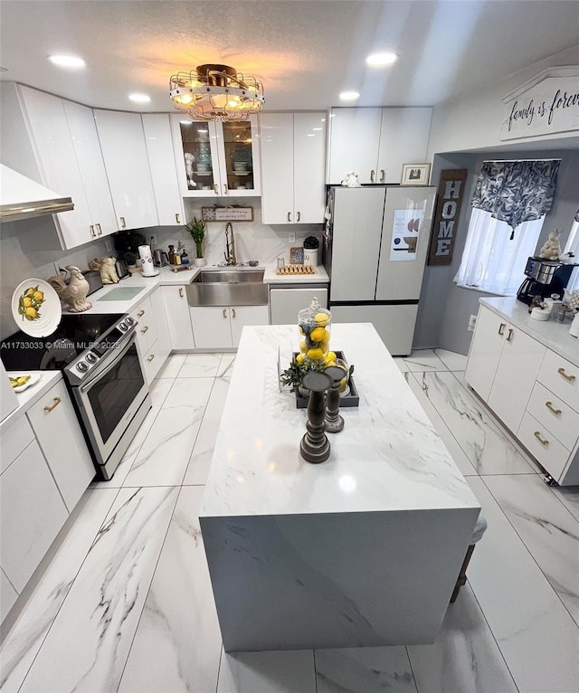 kitchen featuring sink, stainless steel electric range, tasteful backsplash, white cabinets, and white fridge