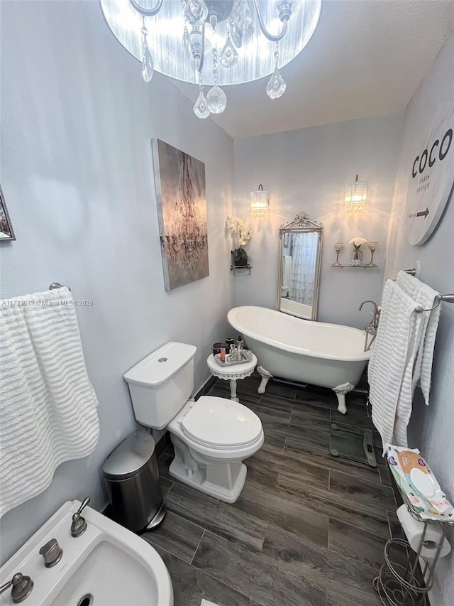 bathroom featuring a washtub, sink, toilet, and a bidet