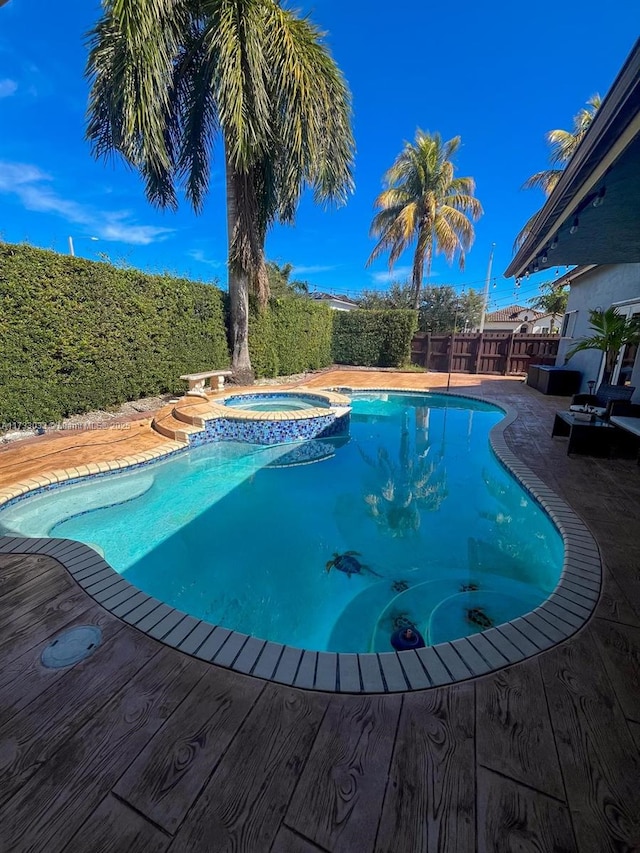 view of swimming pool featuring an in ground hot tub