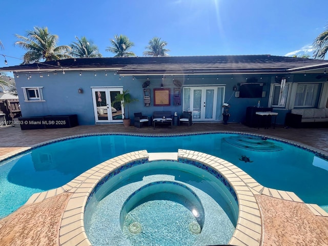 view of pool with french doors, an in ground hot tub, and a patio area