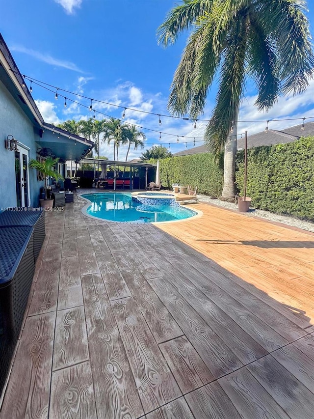 view of swimming pool featuring an in ground hot tub