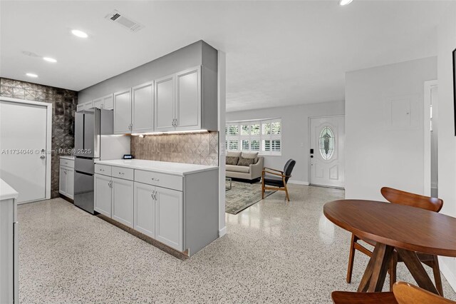 kitchen with sink, backsplash, refrigerator, and stainless steel range with electric stovetop