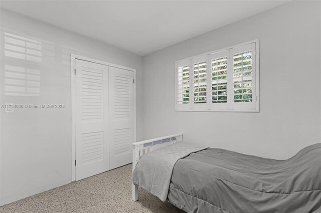 garage featuring stacked washer and clothes dryer and water heater