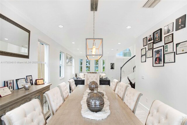 dining room with crown molding, plenty of natural light, and a water view