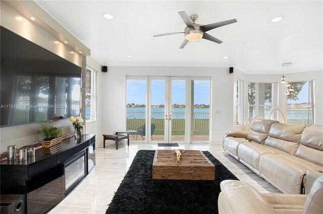 kitchen featuring stainless steel fridge, hanging light fixtures, a water view, a kitchen bar, and wall chimney exhaust hood