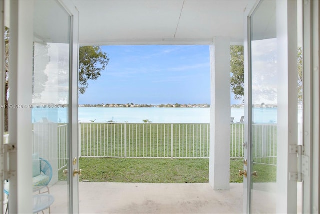 interior space with a water view and french doors