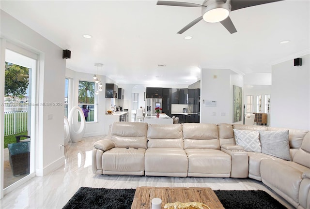 living room featuring ornamental molding and ceiling fan