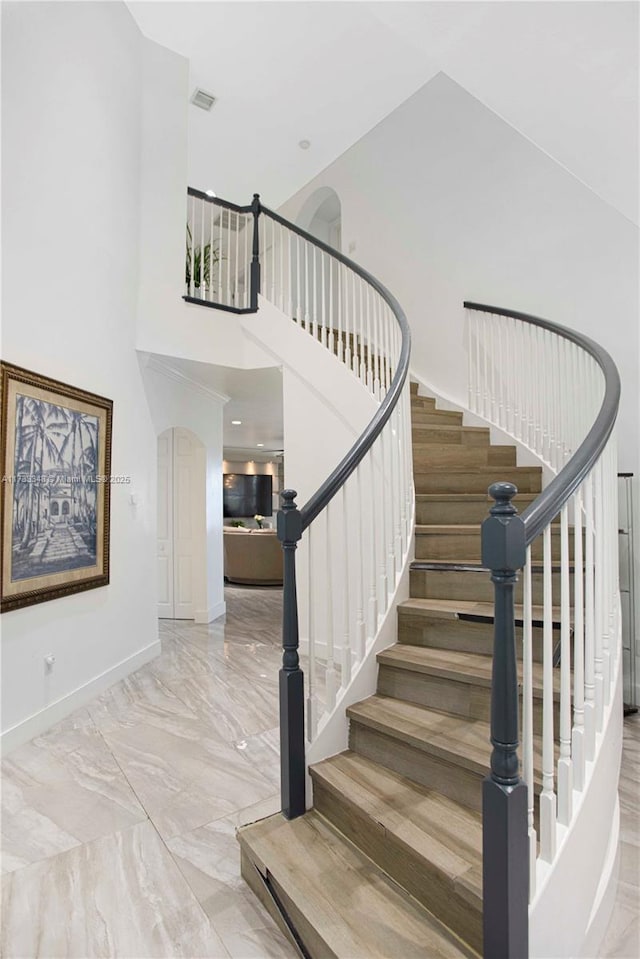 staircase with a towering ceiling