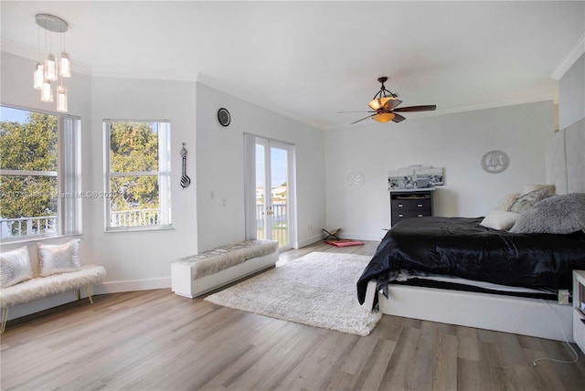 bedroom featuring light hardwood / wood-style flooring, access to exterior, ceiling fan, crown molding, and french doors