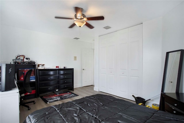 bedroom with hardwood / wood-style floors, ceiling fan, and a closet