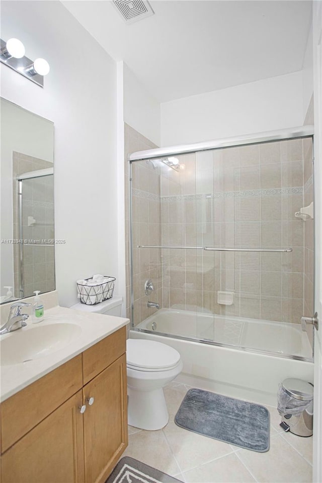 full bathroom with toilet, tile patterned floors, bath / shower combo with glass door, and vanity