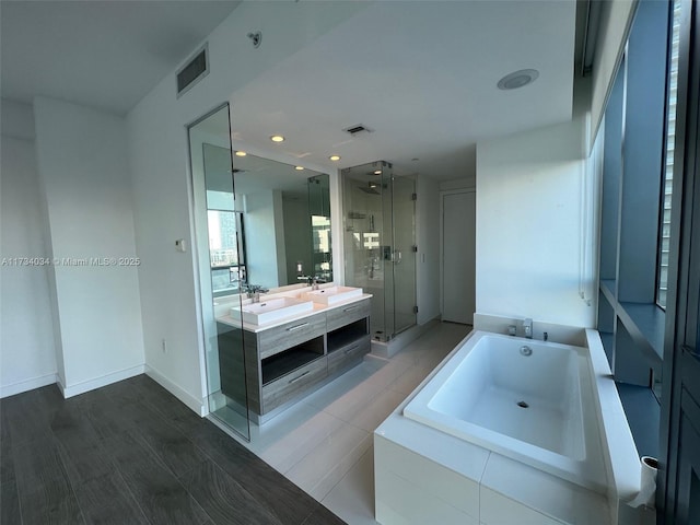 bathroom with vanity and shower with separate bathtub