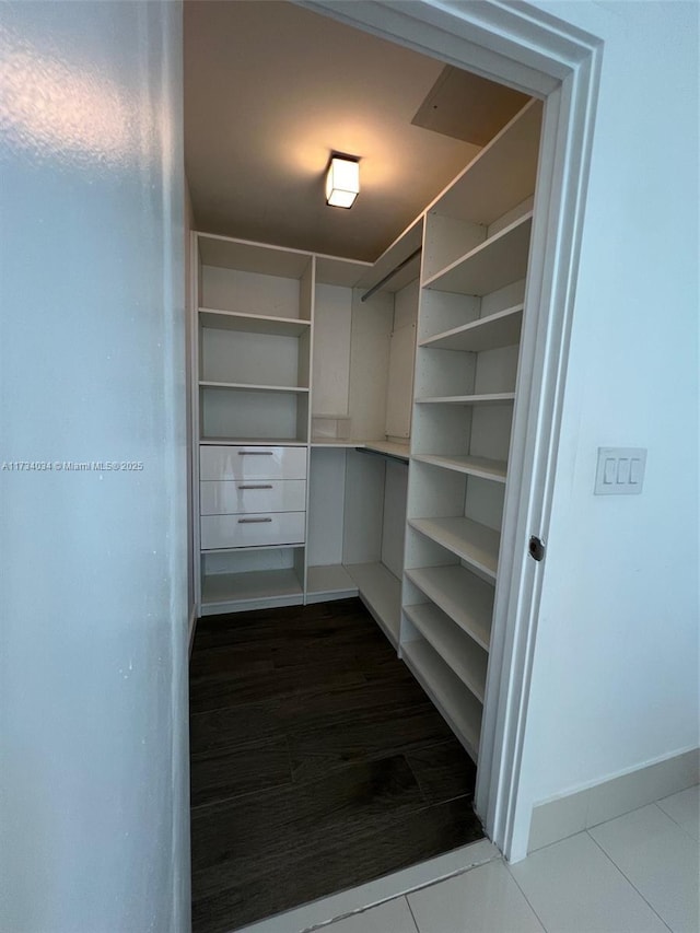 walk in closet featuring dark tile patterned flooring