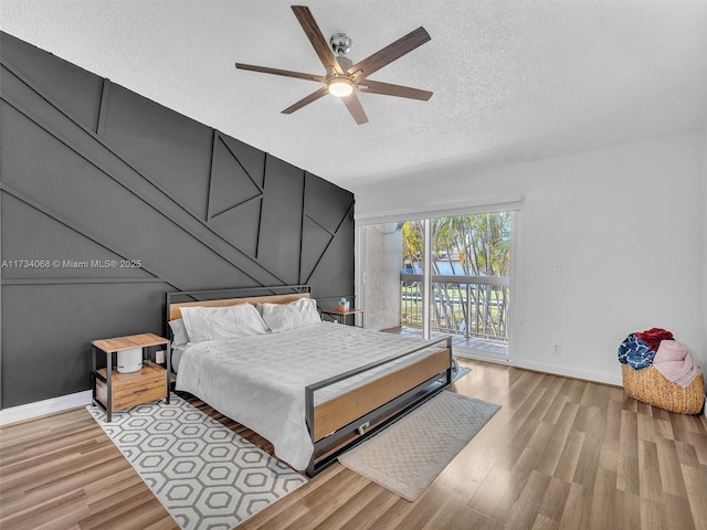 bedroom featuring a textured ceiling, access to exterior, ceiling fan, and light hardwood / wood-style floors