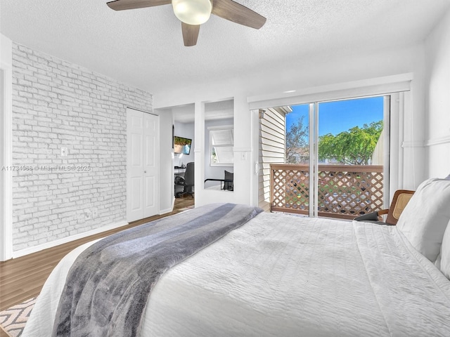 bedroom featuring multiple windows, dark hardwood / wood-style floors, a textured ceiling, and ceiling fan