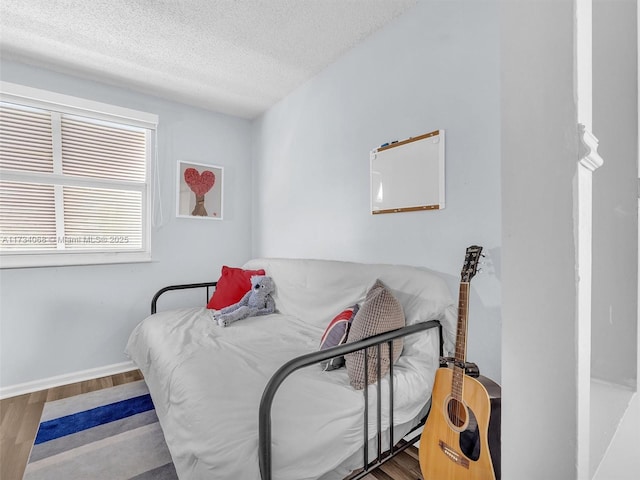 bedroom with hardwood / wood-style flooring and a textured ceiling