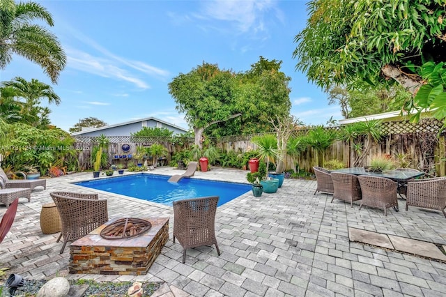 1401 NE 33rd St, Oakland Park, FL 33334 - view of swimming pool featuring an outdoor fire pit, a fenced backyard, a fenced in pool, outdoor dining space, and a patio area