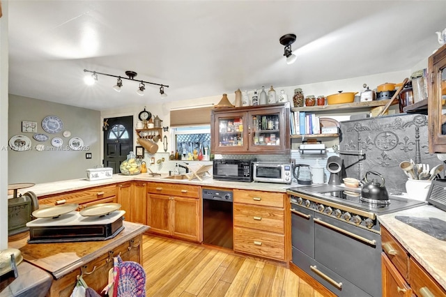 kitchen with decorative backsplash, range with two ovens, and light wood-type flooring