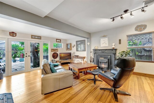 living room featuring track lighting, light hardwood / wood-style floors, and french doors