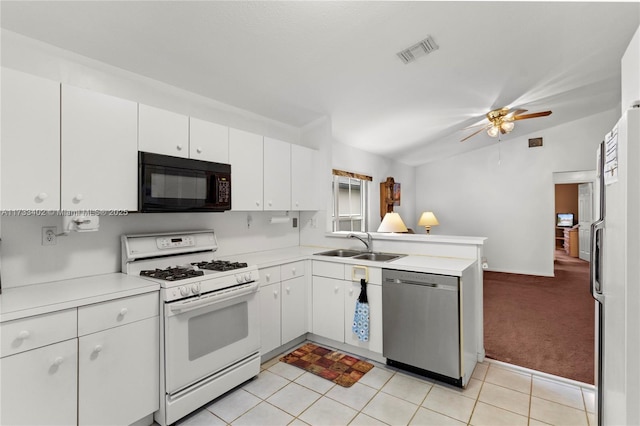 kitchen with sink, white appliances, light tile patterned floors, white cabinetry, and kitchen peninsula