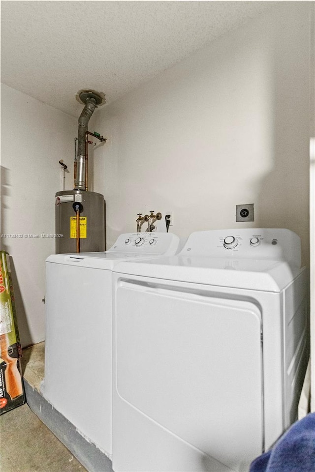 laundry area with a textured ceiling, washer and dryer, and gas water heater