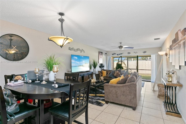 dining area featuring light tile patterned flooring, ceiling fan, and a textured ceiling