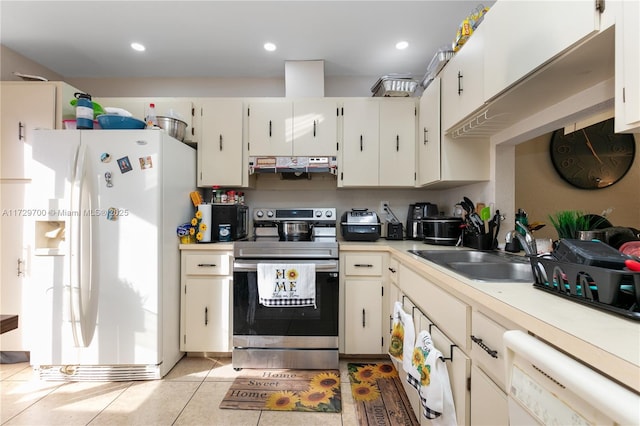 kitchen with sink, white appliances, white cabinets, and light tile patterned flooring