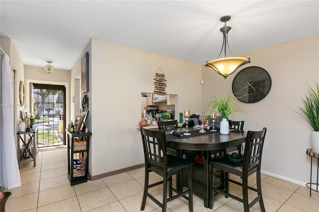 dining room featuring light tile patterned floors and a textured ceiling