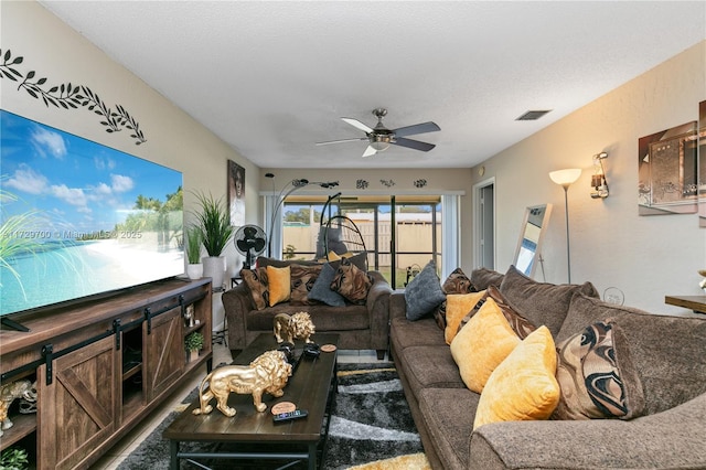 living room with ceiling fan and a textured ceiling