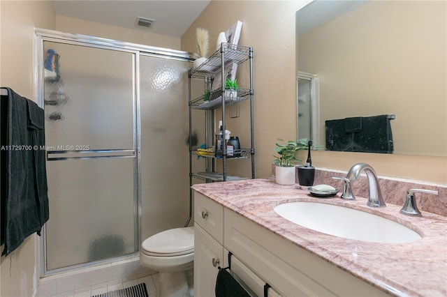 bathroom featuring an enclosed shower, vanity, tile patterned floors, and toilet