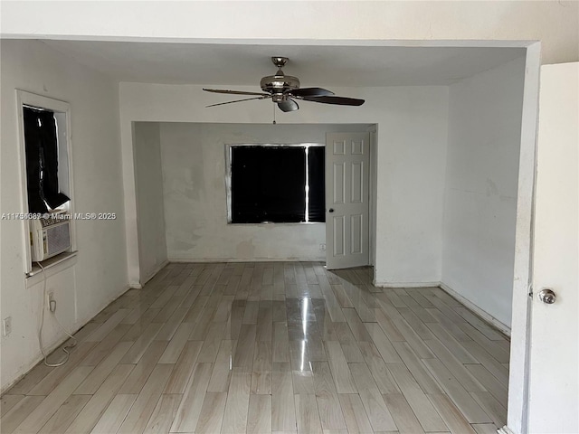 unfurnished room with cooling unit, ceiling fan, and light wood-type flooring