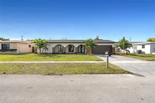 view of front facade featuring an attached garage, a front lawn, concrete driveway, and stucco siding