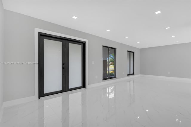 empty room with marble finish floor, baseboards, and french doors