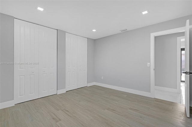 interior space featuring light wood-style floors, visible vents, and baseboards