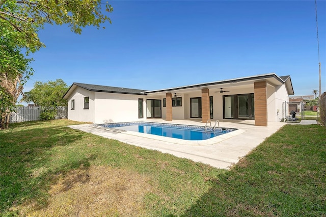 back of house featuring a patio, stucco siding, a lawn, a ceiling fan, and fence