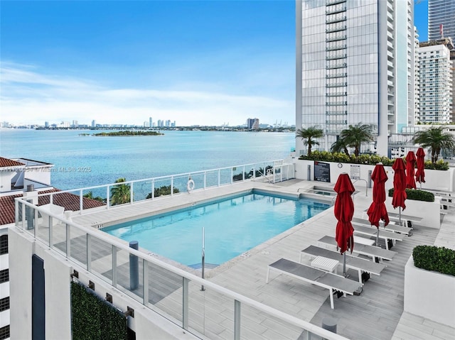 view of swimming pool featuring a patio and a water view